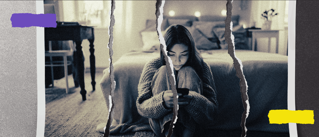 A girl sitting on the ground, looking at her phone.